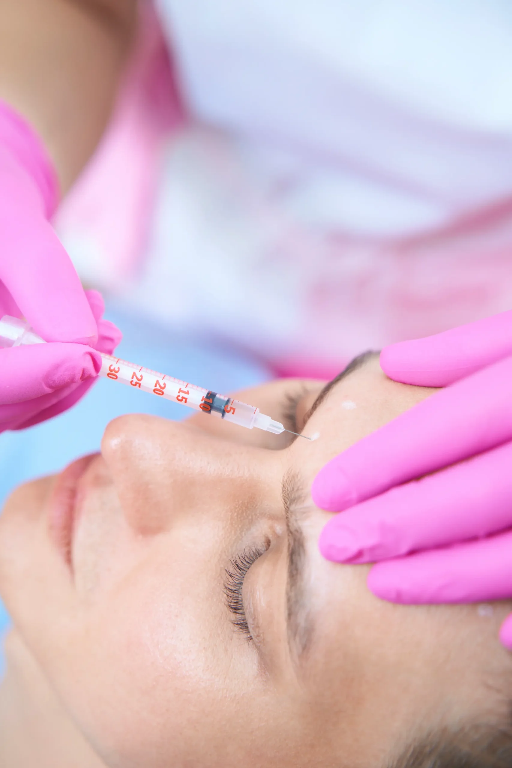 Muž při injekčním ošetření vrásek v estetické klinice